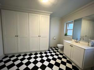 a bathroom with a black and white checkered floor at Penny Royal Guest Cottages in Somerset West +34 photos