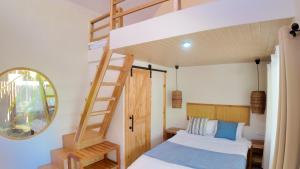 a bedroom with a bunk bed and a ladder at Bom Dia Siargao Villas in General Luna