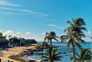 a view of a beach with palm trees and the ocean at Hotel Bela Vista in Salvador