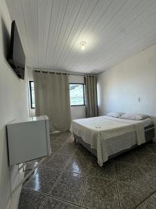 a bedroom with a bed and a flat screen tv at Hotel Bela Vista in Salvador