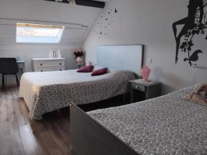 a bedroom with two beds and a desk and a window at Gîte de campagne Dromard in Sancey-le-Grand