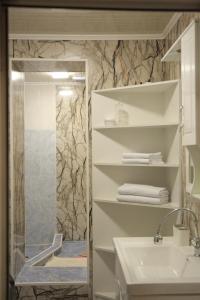 a bathroom with a shower and a sink and a mirror at Central Guest House Karakol in Karakol