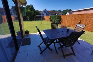 a black table and chairs on a patio at PINE COTTAGE Self catering fully equipped 2 bedroom, Queen bed 3 singles 65sqm cosy private cottage in Durban