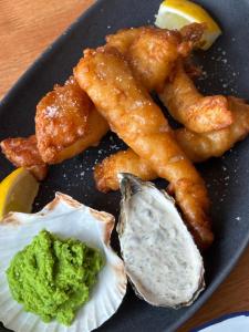 a plate of food with shrimp and guacamole and a lemon at Viking House Hotel Donegal in Kincasslagh