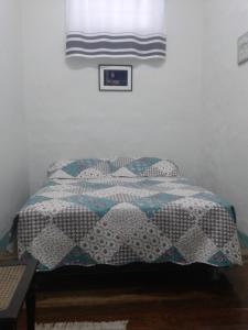een bed met een dekbed in een slaapkamer bij Hostel Imperial in Ouro Preto
