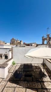 a white umbrella and chairs on a roof at Lumia - Casa Vacanze in Martina Franca