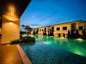 a swimming pool in front of a building at night at Sunway Onsen Apartment Tambun by ELK Homestay in Tambun