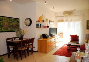 a living room with a table and a clock on the wall at La Collina D'Oro in Cernobbio