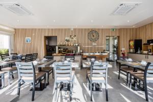 a restaurant with tables and chairs and a kitchen at Hôtel de France Contact-Hôtel in Évian-les-Bains