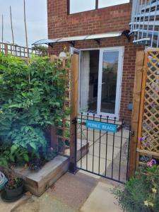 a gate to a house with a gate agent sign on it at Pebble Beach, ground floor 1 bedroom flat in Chichester