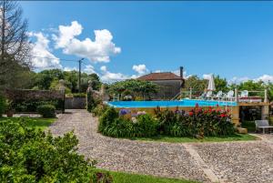 a garden with a swimming pool and flowers at Casa de Alderete in Valença +37 photos
