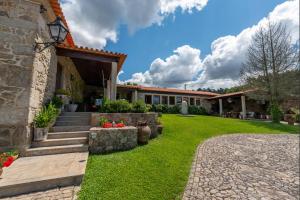a house with a green yard with stairs and flowers at Casa de Alderete in Valença