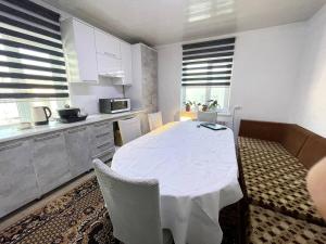 a kitchen with a table and chairs in a room at Hanbiike in Karakol