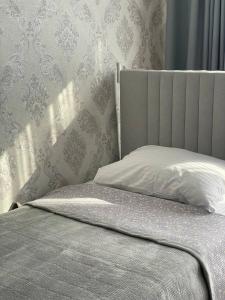 a bedroom with a bed with a headboard and wallpaper at Hanbiike in Karakol