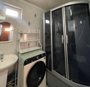 a bathroom with a washing machine and a sink at Hanbiike in Karakol