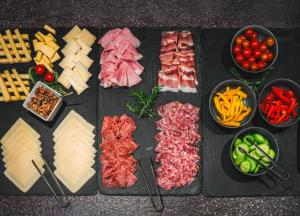 a table with meats and cheese and bowls of vegetables at Hotel Sachsenklemme in Fortezza