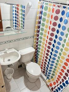 a bathroom with a toilet and a sink and a shower curtain at Alegría Lodge in Curití +53 photos