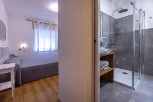 a bathroom with a shower and a bed in a room at Hotel Al Molino in Malcesine +207 photos