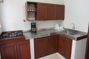 a kitchen with wooden cabinets and a sink and a stove at Casa Esperanza in Cali