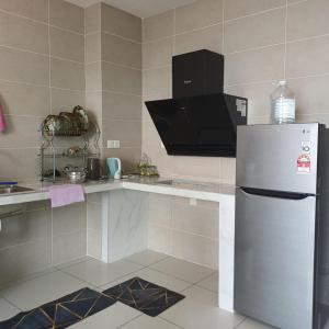 a kitchen with a refrigerator and a microwave at Sunway Onsen Apartment Tambun by ELK Homestay in Tambun