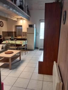 a kitchen with a table and a refrigerator at gite du guip in Trégourez +14 photos