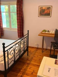 a bedroom with a bed and a desk and a window at Philoxenia in Spata