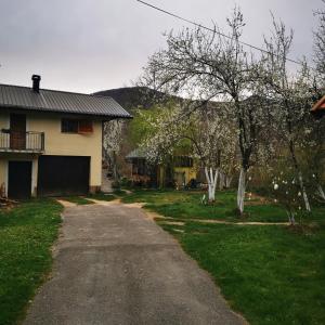 a dirt road next to a house and some trees at Kuća za odmor Tomislav in Trnovdc
