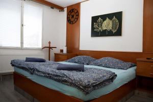 a bedroom with two beds and a cross on the wall at Chata Na Pasekách in Rajnochovice