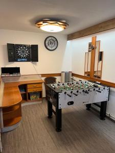 a ping pong table in a room with a clock at Chata Na Pasekách in Rajnochovice