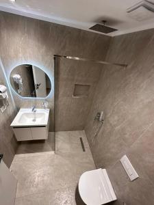 a bathroom with a shower and a sink and a toilet at Logan Rooms Berat in Berat