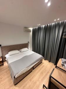 a bedroom with a bed and a large window at Logan Rooms Berat in Berat +54 photos