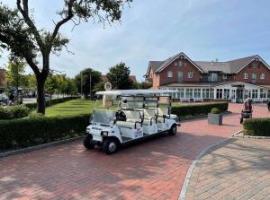 a golf cart is parked on a brick road at Seaside-Amrum-16 in Norddorf +10 photos
