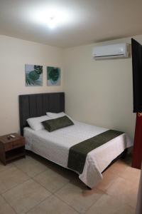 a bedroom with a bed and a nightstand next to it at Casa Esperanza in Cali