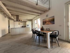kuchnia i jadalnia ze stołem i krzesłami w obiekcie Charme Lake Loft w mieście Ispra