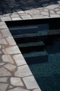 a pool of water on the side of a sidewalk at Villa Petra in Andros