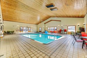 a swimming pool in a large room with a wooden ceiling at Country Inn Walker in Walker