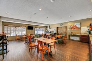 a restaurant with tables and chairs and a kitchen at Country Inn Walker in Walker