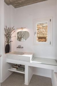 a white bathroom with a sink and a window at Villa Petra in Andros +66 photos