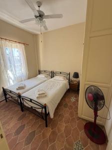 a bedroom with a bed and a fan in it at PALIO LIMANI APARTMENTS in Spetses