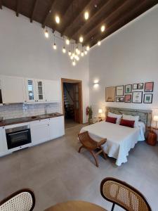 a bedroom with a white bed and a kitchen at Apartamentos La Florida in Arrecife