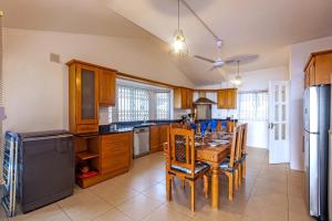 a kitchen with a table and chairs and a refrigerator at Bahari Villa Beachfront in Port Louis