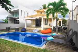 a swimming pool in the backyard of a house at Bahari Villa Beachfront in Port Louis