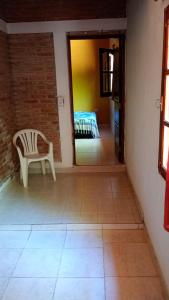 a chair sitting in a room with a tile floor at Aloe in Mina Clavero