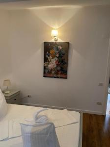 a bedroom with a painting of flowers on the wall at Dare apartments 2 in Giurgiu +1 photo