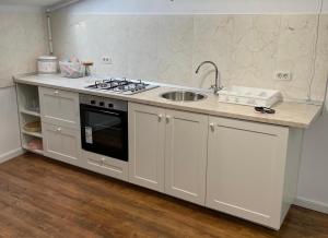 a kitchen with a sink and a stove top oven at Dare apartments 2 in Giurgiu