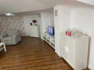 a living room with a couch a chair and a television at Dare apartments 2 in Giurgiu