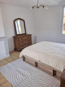 a bedroom with a bed and a mirror and a dresser at L'escale de Blacourt in Blacourt