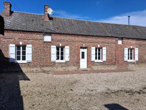 a brick building with white windows and a roof at L'escale de Blacourt in Blacourt +5 photos