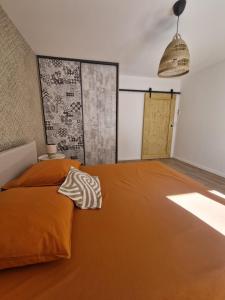 a bedroom with a bed with an orange blanket at La place in Pont-de-Vaux +6 photos