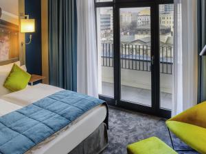 a hotel room with a bed and a large window at MERCURE Hotel Berlin Wittenbergplatz in Berlin +138 photos